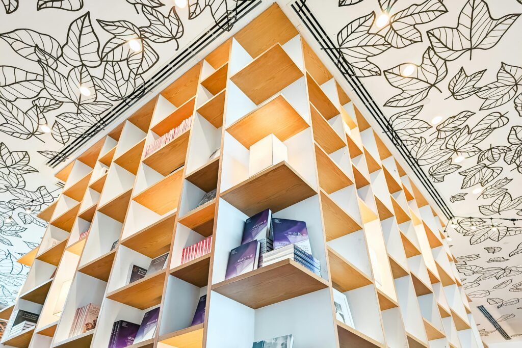 Artistic ceiling and geometric bookshelf in a modern library.